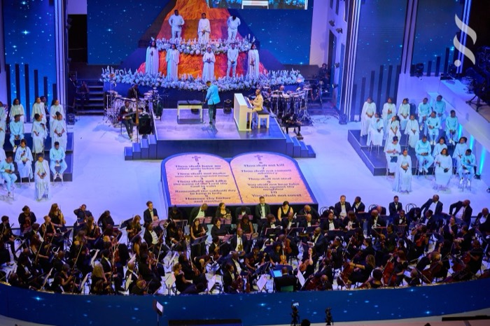 A packed hall under blue stage light at Mwandi Celestial