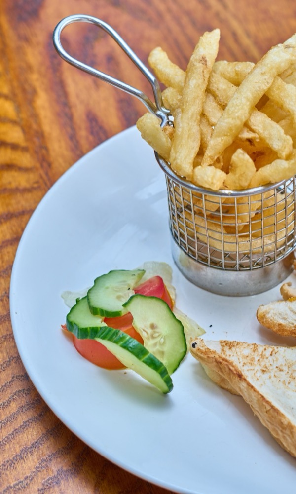 A toasted sandwich and fries plated at Haefelis